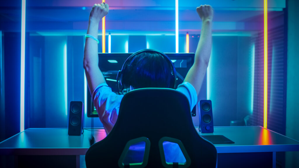 https://www.minnanosyougai.com/facility/item/47783/professional-gamer-playing-and-winning-in-first-person-shooter-online-video-game-on-his-personal-computer-footage-fade-out-into-bokeh-room-lit-by-neon-lights-in-retro-arcade-style-cyber-sport-champ/